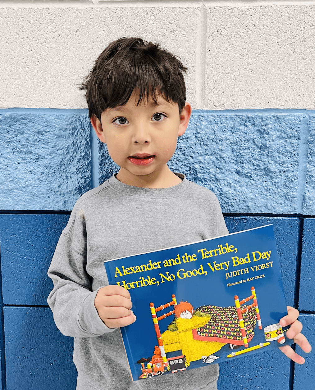 student holding a book received for earning a  praise award